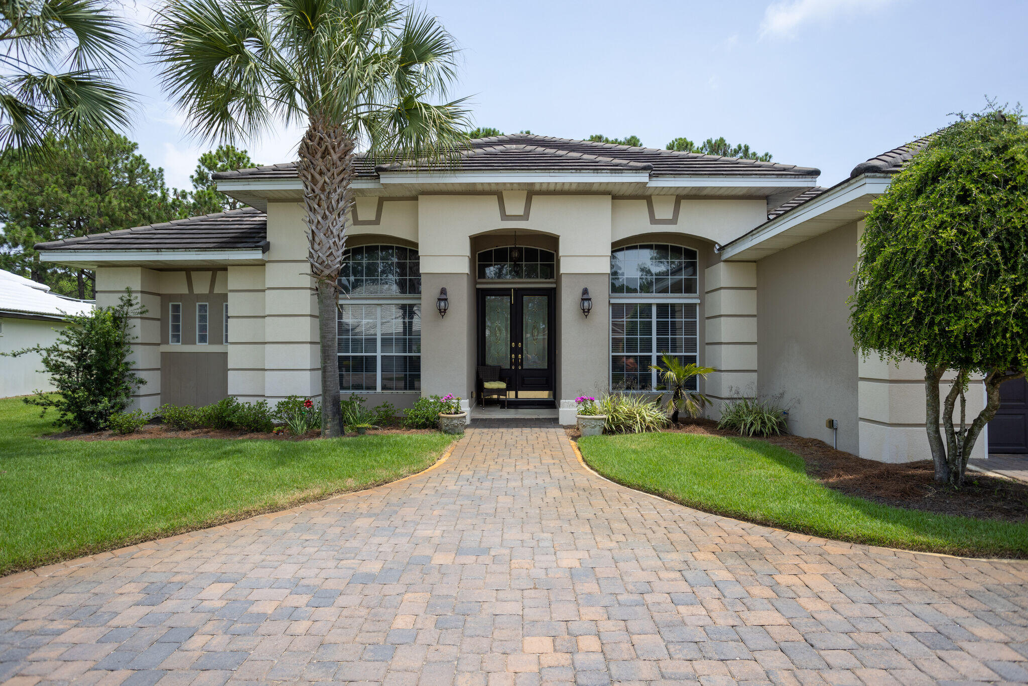 740 Indigo Loop Miramar Beach, FL 32550 - Photo 3 of 39 front view of a house with a yard and palm trees