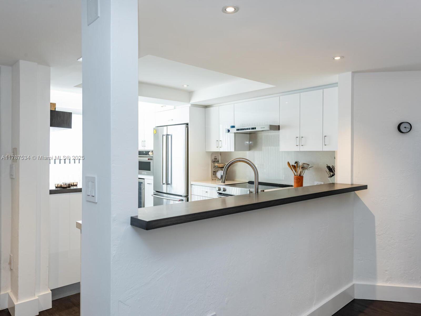 3229 Mary Street, Unit 2 Miami, FL 33133 - Photo 11 of 56 a kitchen with stainless steel appliances granite countertop a sink refrigerator and cabinets