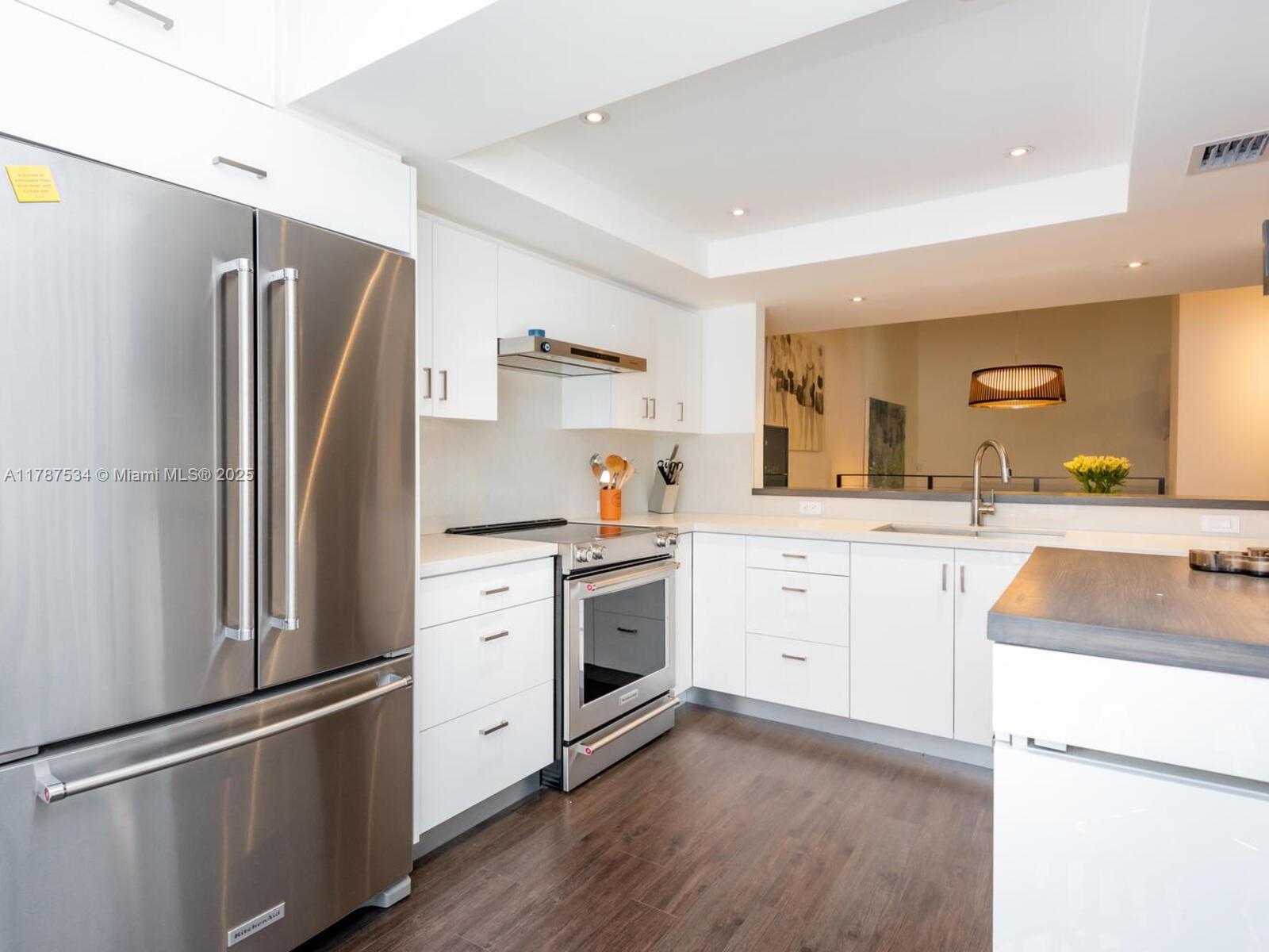 3229 Mary Street, Unit 2 Miami, FL 33133 - Photo 15 of 56 a kitchen with white cabinets and stainless steel appliances