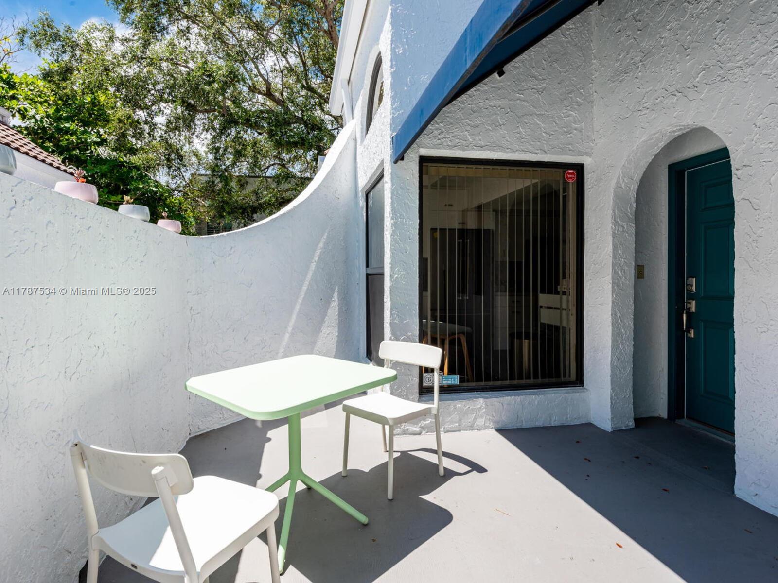 3229 Mary Street, Unit 2 Miami, FL 33133 - Photo 7 of 56 a view of a patio with a table and chairs and potted plants