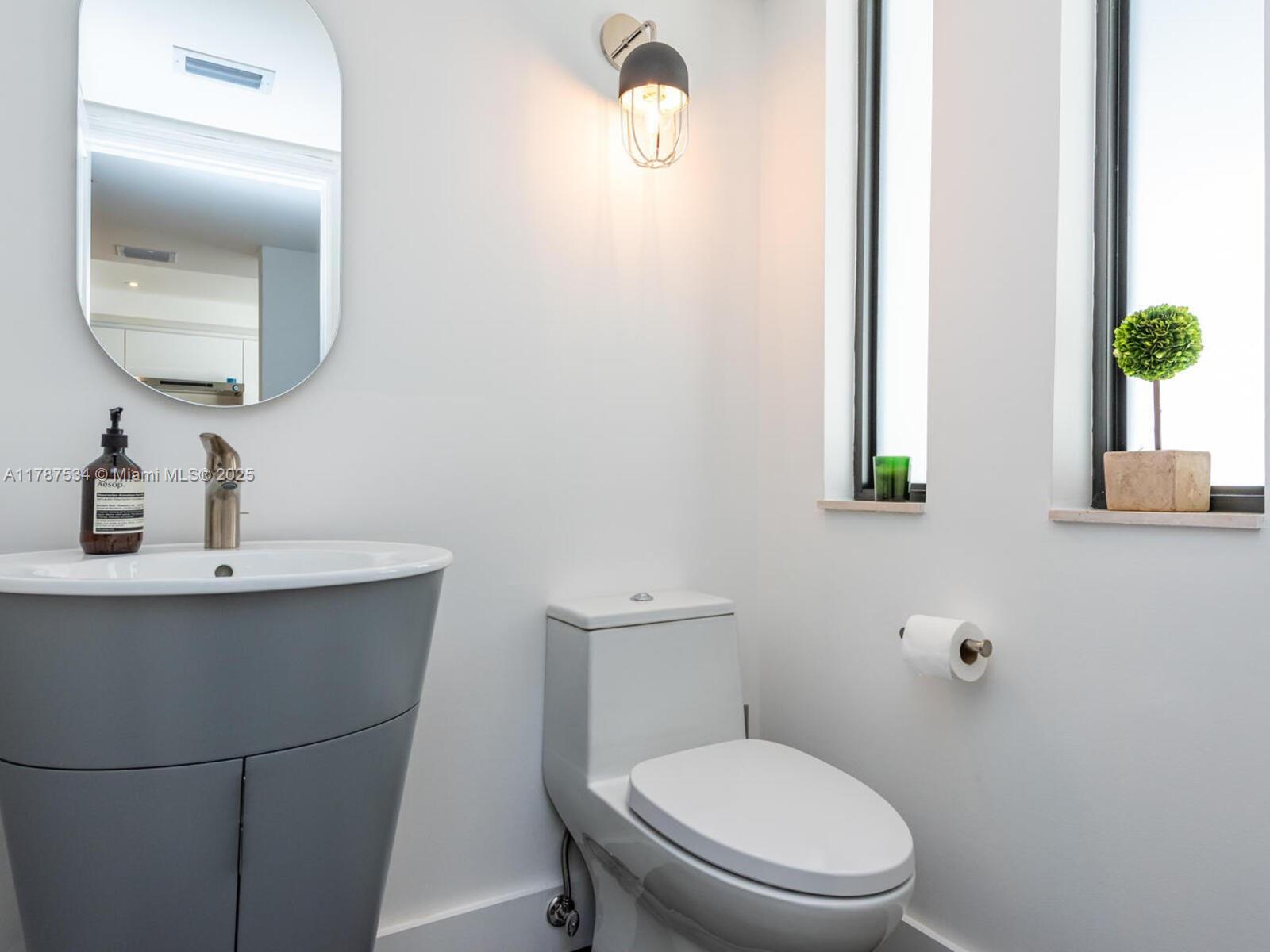 3229 Mary Street, Unit 2 Miami, FL 33133 - Photo 9 of 56 a bathroom with a toilet a sink and mirror
