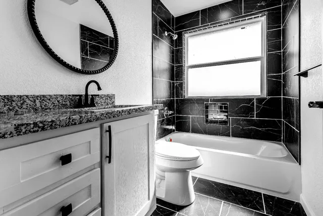 a bathroom with a granite countertop sink and a mirror