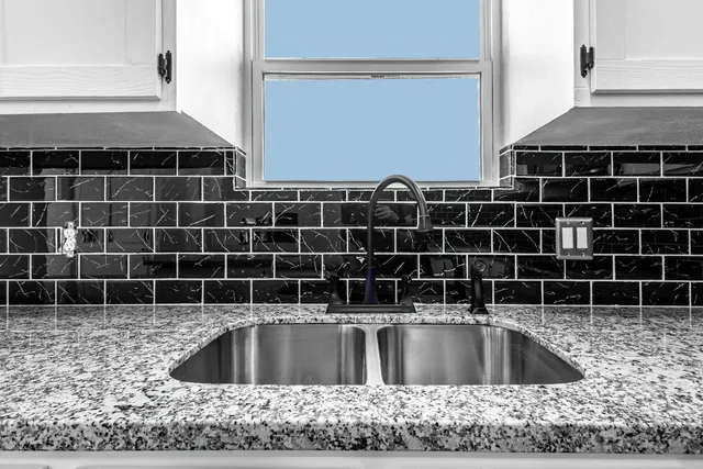 a kitchen with granite countertop white cabinets stainless steel appliances and sink