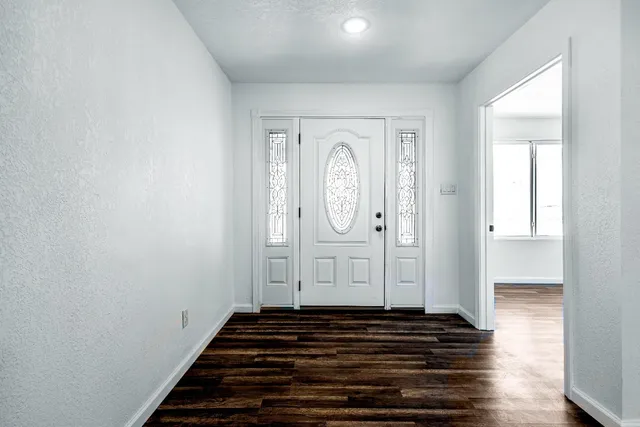 a view of a hallway with wooden floor and entryway