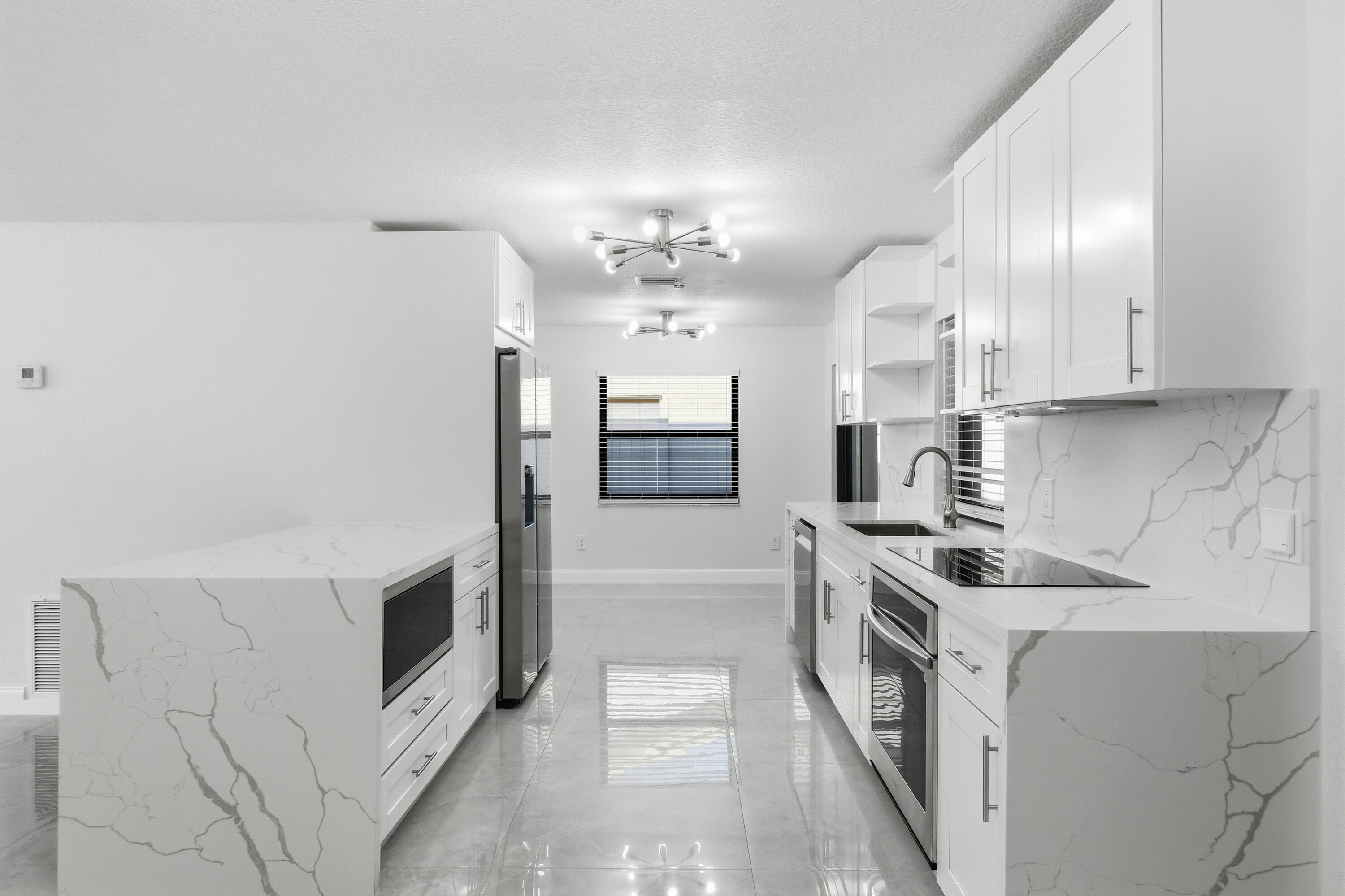 22390 Southwest 66th Avenue Boca Raton, FL 33428 - Photo 17 of 58 a kitchen with stainless steel appliances granite countertop a stove and a sink