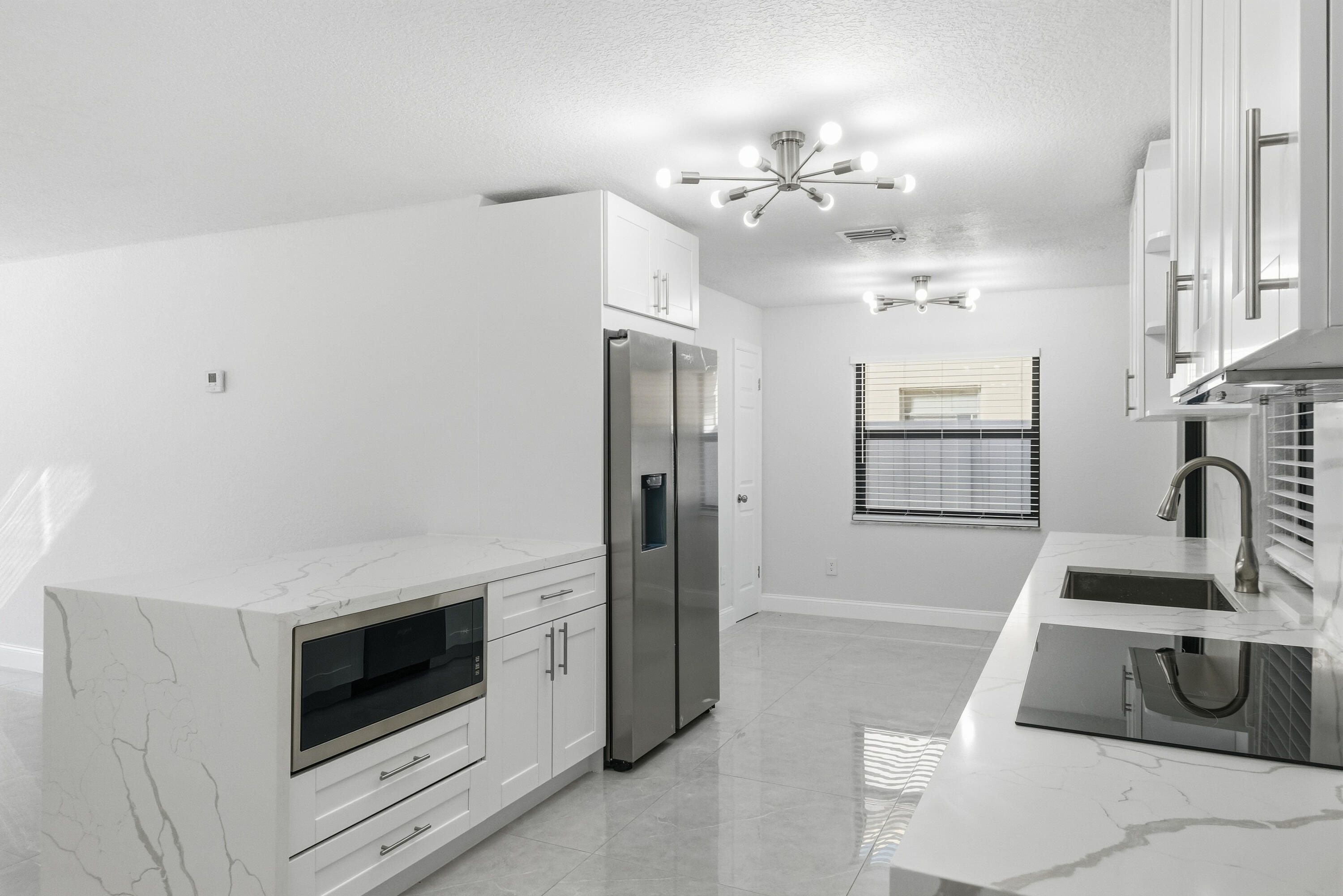 22390 Southwest 66th Avenue Boca Raton, FL 33428 - Photo 19 of 58 a kitchen with granite countertop a sink and a stove top oven with wooden floor