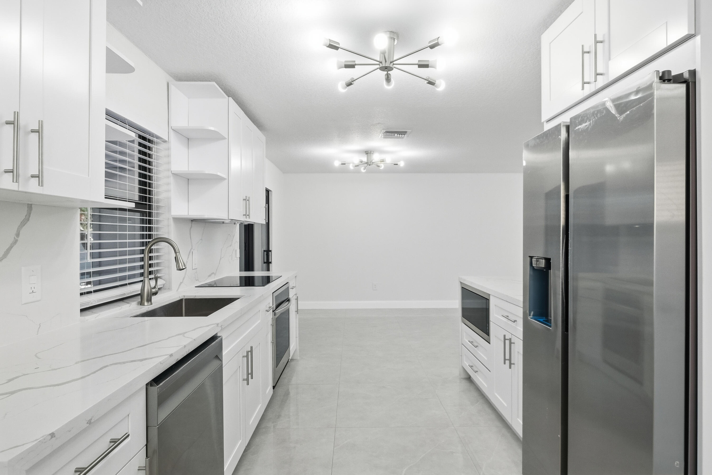 22390 Southwest 66th Avenue Boca Raton, FL 33428 - Photo 23 of 58 a kitchen with stainless steel appliances granite countertop a sink a stove and a refrigerator