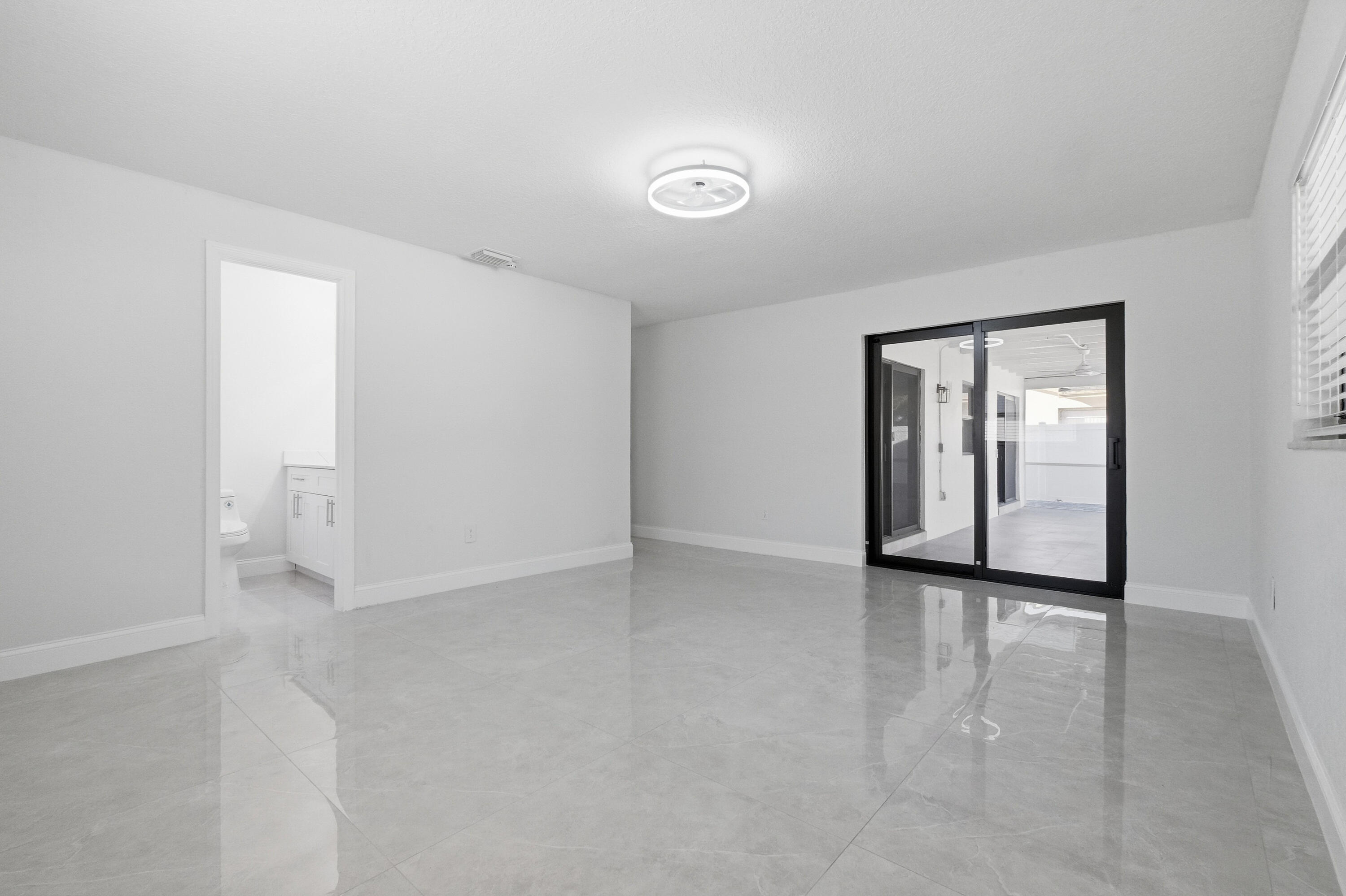 22390 Southwest 66th Avenue Boca Raton, FL 33428 - Photo 37 of 58 a view of an empty room with window and wooden floor