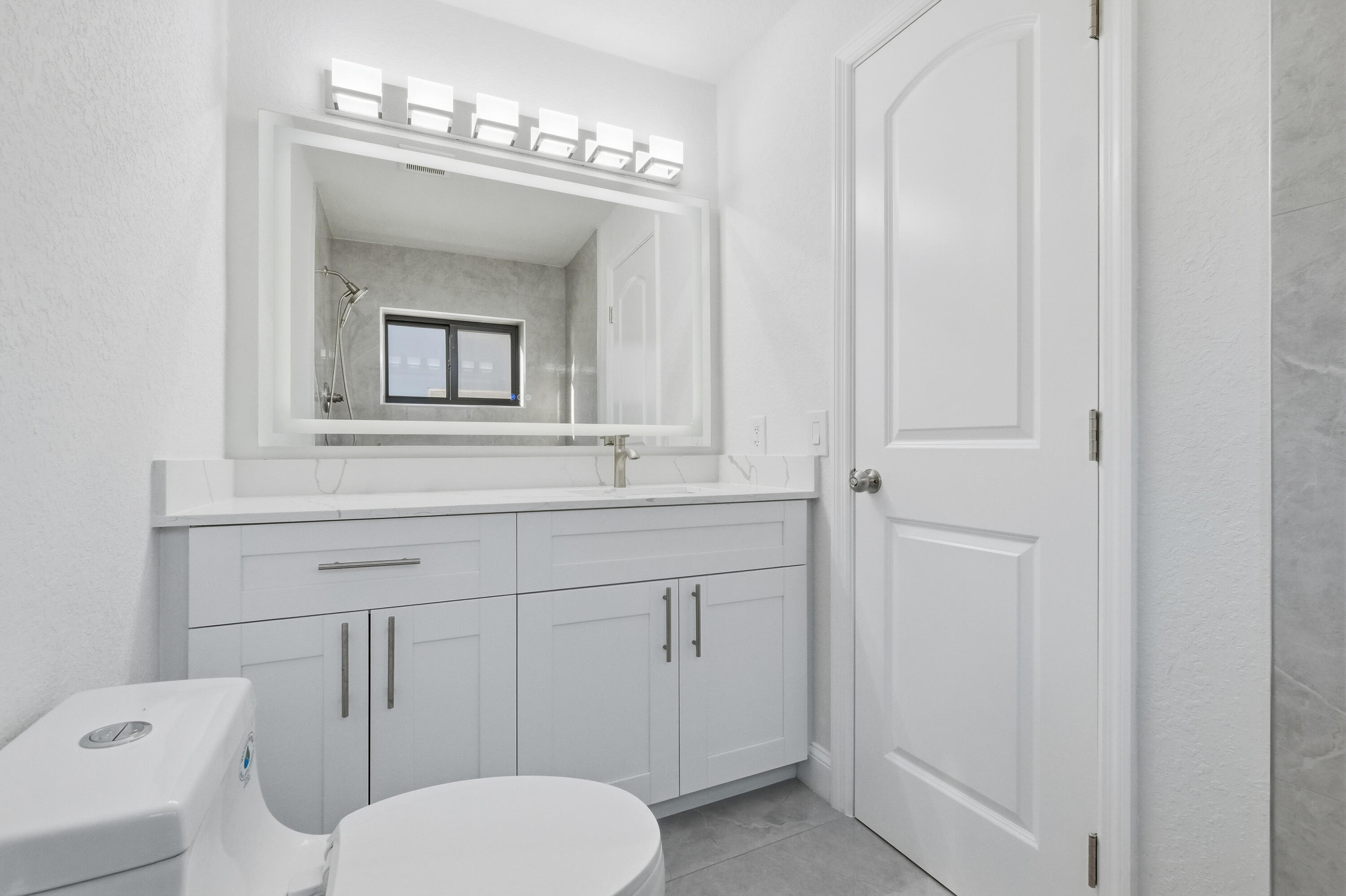 22390 Southwest 66th Avenue Boca Raton, FL 33428 - Photo 38 of 58 a bathroom with a toilet a sink and mirror