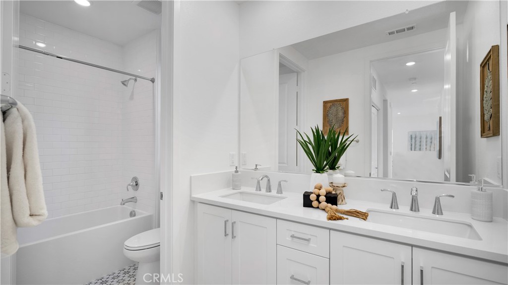 113 Junco Irvine, CA 92618 - Photo 27 of 47 a bathroom with a granite countertop sink a toilet a large mirror a vanity and shower
