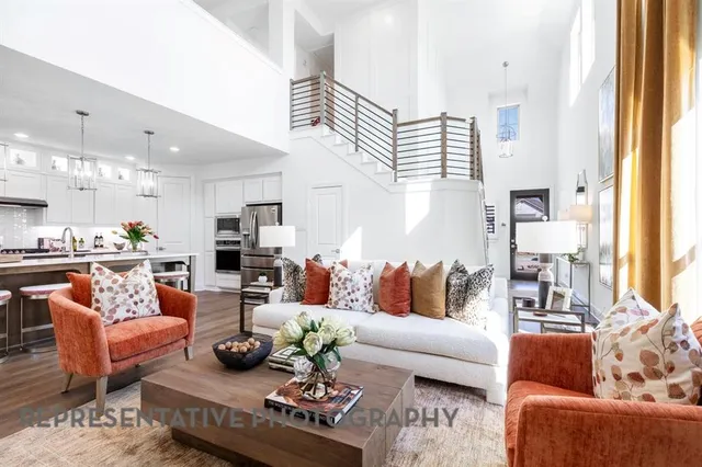 a living room with furniture kitchen view and a large window