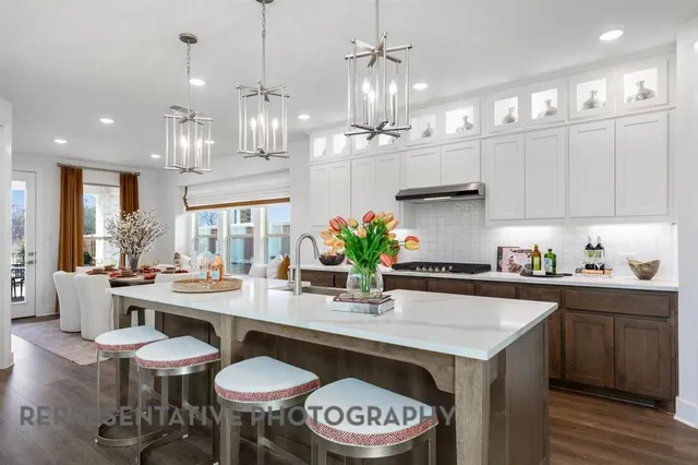 a kitchen with stainless steel appliances a table and chairs in it