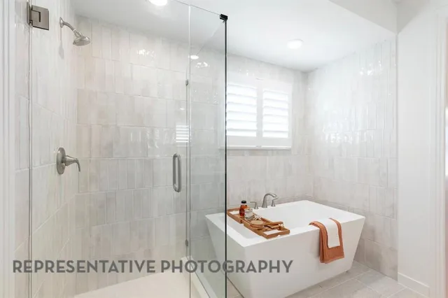 a bathroom with a tub a mirror and a shower