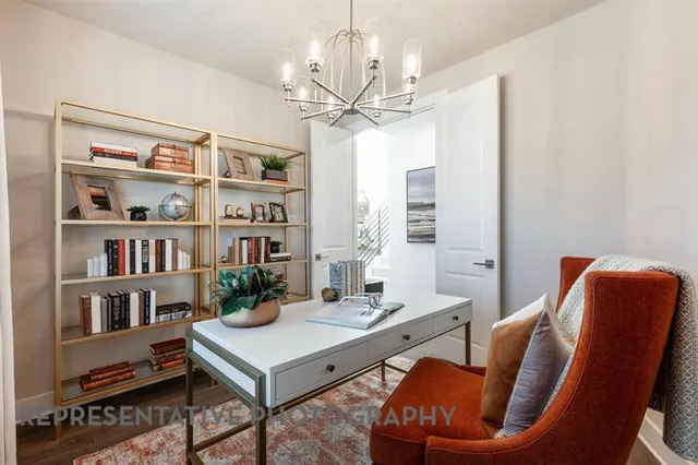 a living room with furniture a bookshelf and a window