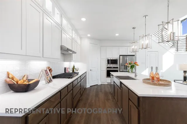 a kitchen with stainless steel appliances granite countertop a sink a stove and a wooden floors