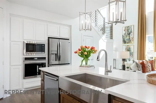 a kitchen with stainless steel appliances granite countertop a sink and a refrigerator