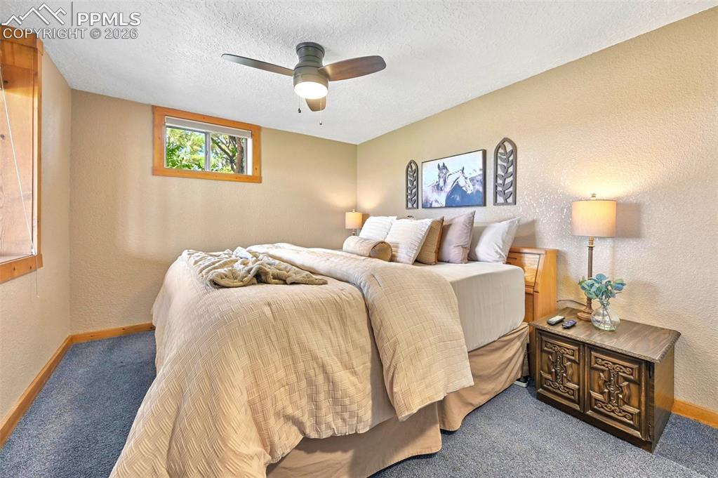 18560 Chelton Road Ramah, CO 80832 - Photo 23 of 34 a spacious bedroom with a bed and a lamp