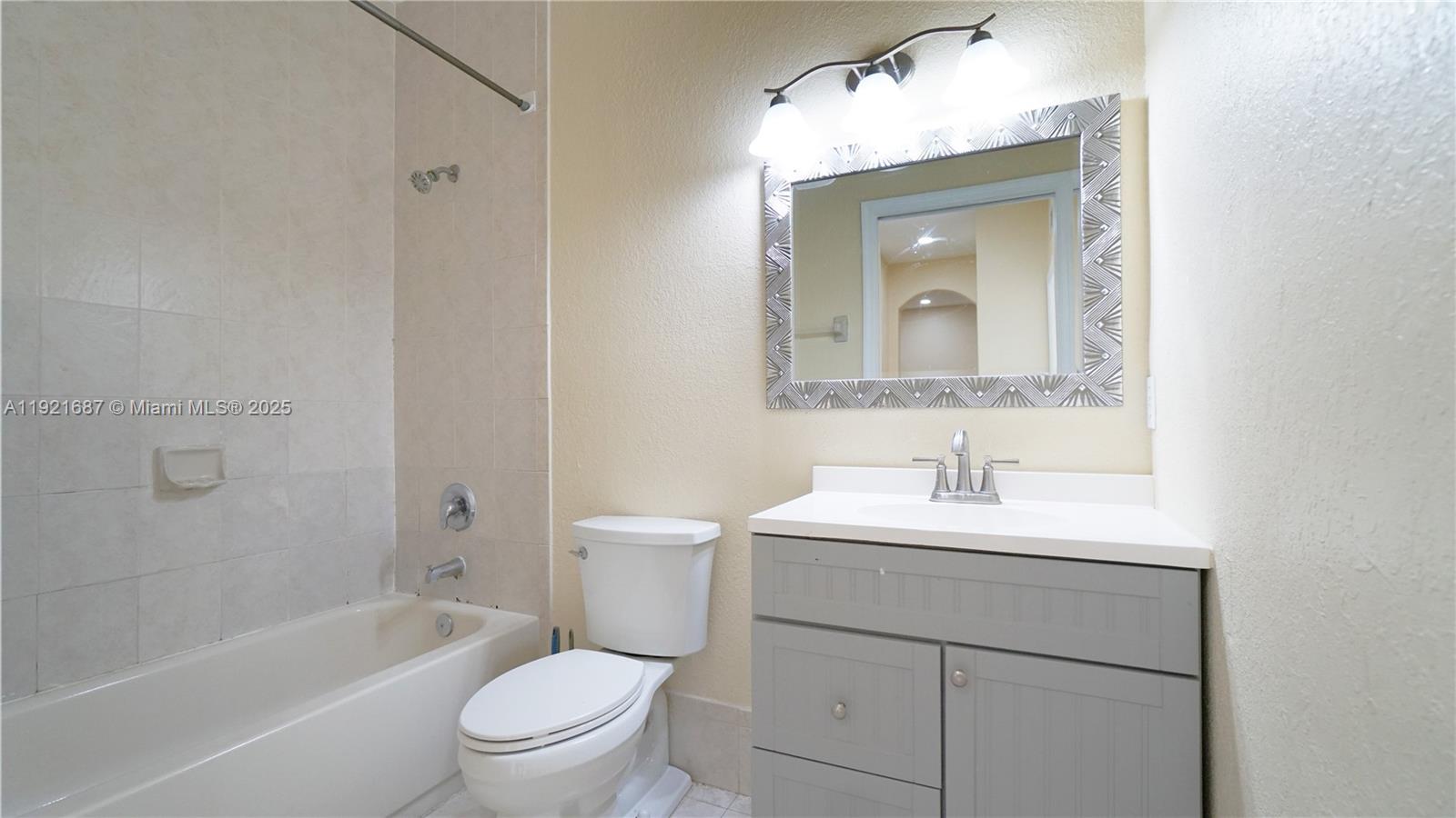 1535 Southeast 26th Street, Unit 103 Homestead, FL 33035 - Photo 10 of 26 a bathroom with a toilet a sink a mirror and vanity