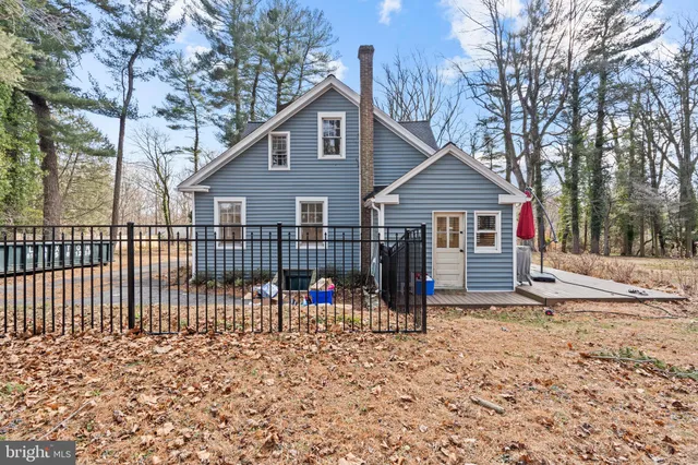 a view of a house with a small yard and wooden fence