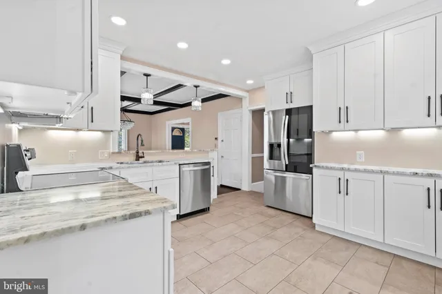a kitchen with granite countertop a sink stainless steel appliances and counter space