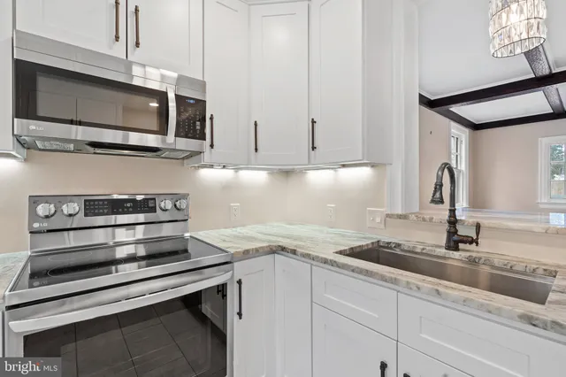 a kitchen with stainless steel appliances granite countertop a sink and a stove