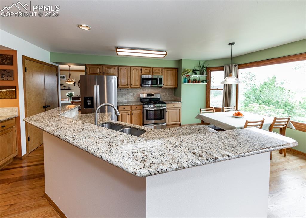 2145 Wickes Road Colorado Springs, CO 80919 - Photo 13 of 50 a kitchen with stainless steel appliances granite countertop a sink stove and refrigerator