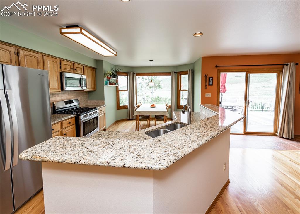 2145 Wickes Road Colorado Springs, CO 80919 - Photo 14 of 50 a kitchen with granite countertop sink refrigerator and large window
