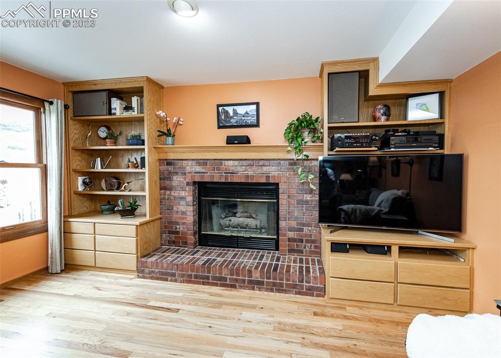 2145 Wickes Road Colorado Springs, CO 80919 - Photo 20 of 50 a living room with a fireplace a flat screen tv and a counter top space