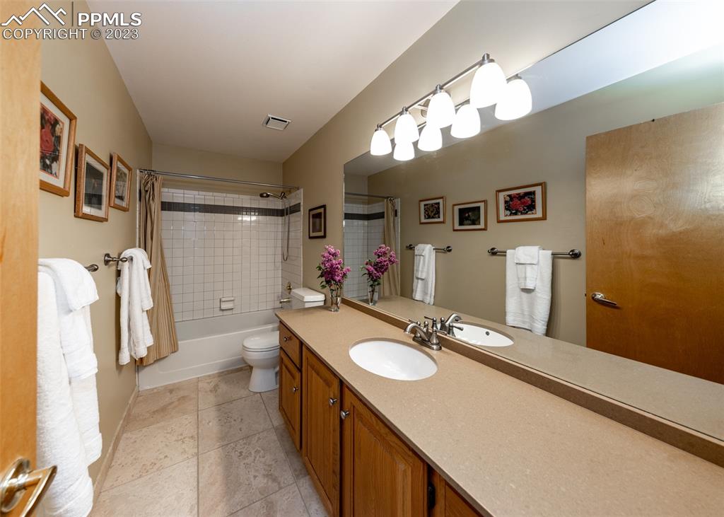 2145 Wickes Road Colorado Springs, CO 80919 - Photo 31 of 50 a bathroom with a sink a large mirror and a shower