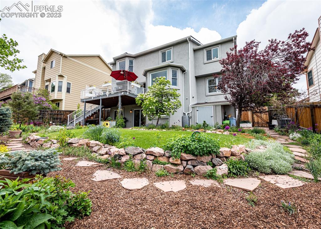 2145 Wickes Road Colorado Springs, CO 80919 - Photo 44 of 50 a view of a white house with a patio and a garden