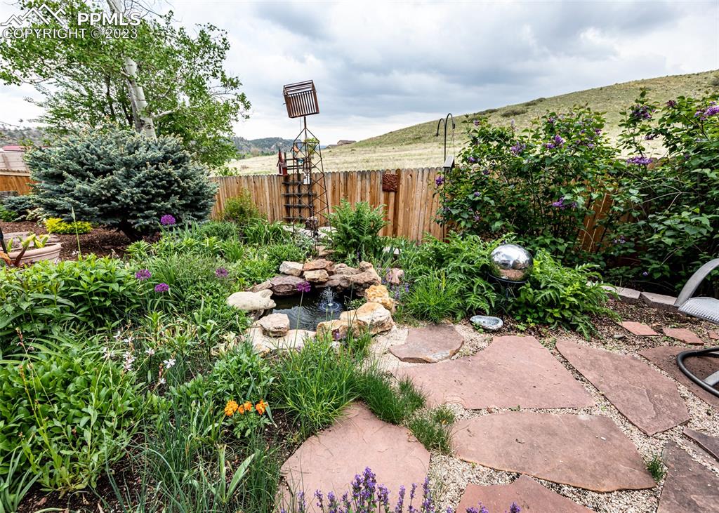 2145 Wickes Road Colorado Springs, CO 80919 - Photo 45 of 50 a backyard of a house with a garden and plants
