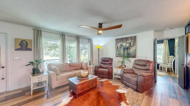 a living room with furniture ceiling fan and a window