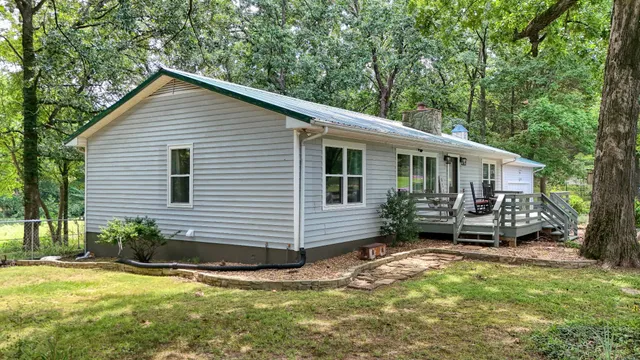 a view of a house with a yard chairs and a small yard