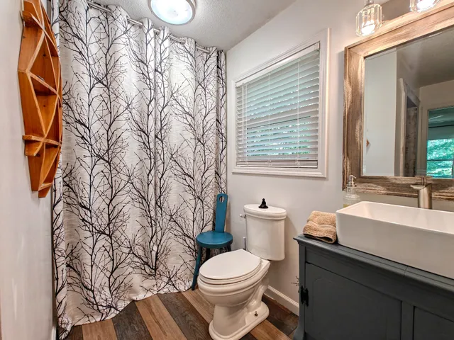 a bathroom with a toilet sink and mirror