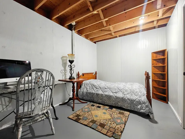 a bedroom with a bed a desk and chair