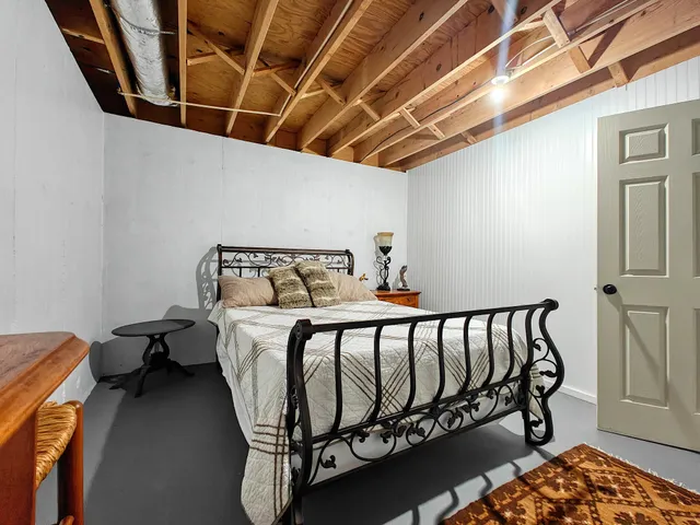 a bed sitting in a bedroom next to a window