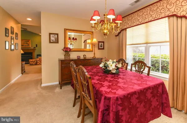 a very nice looking dining room with furniture a chandelier and a large window