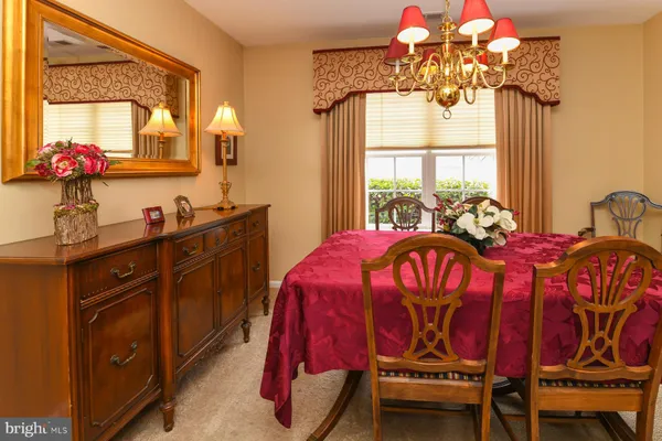 a bedroom with a bed a chandelier and a window