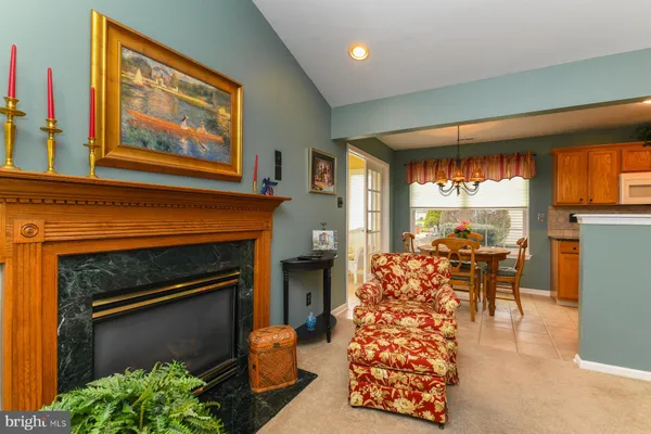 a living room with furniture a fireplace and a large window