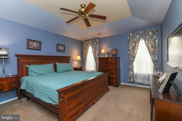 a bedroom with a bed and a flat tv screen on the dresser