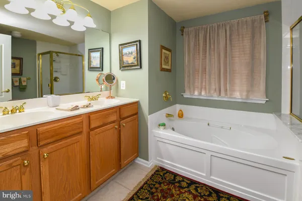 a spacious bathroom with a tub sink and mirror
