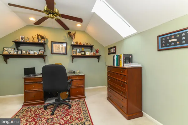 a work room with furniture and paintings on the wall