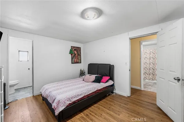 a bedroom with a bed and a wooden floor