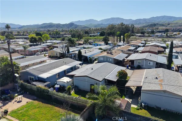 an aerial view of a house with a mountain in the background