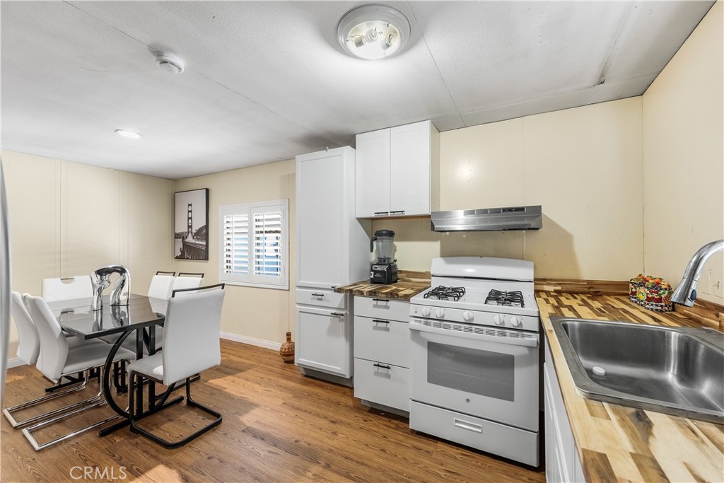 18540 Soledad Canyon Road, Unit 124 Canyon Country, CA 91351 - Photo 6 of 20 a kitchen with a stove a sink and a refrigerator