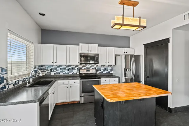 a kitchen with kitchen island a sink stainless steel appliances and cabinets