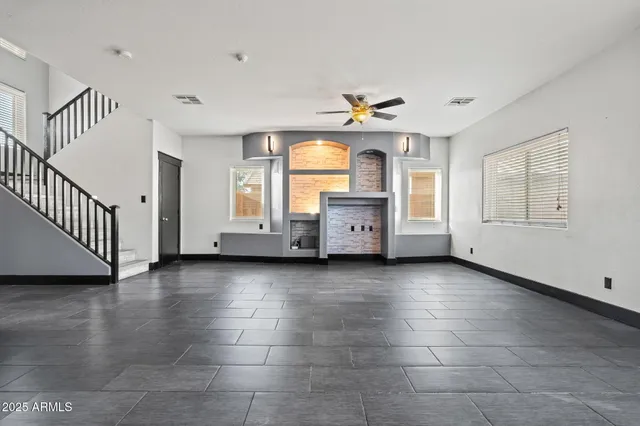 a view of an empty room with a window and fireplace
