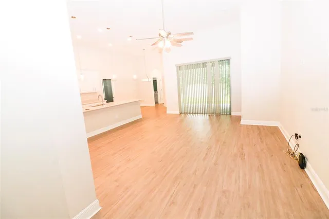 a view of a bedroom with wooden floor and a ceiling fan