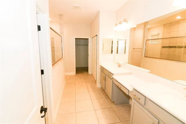 a spacious bathroom with a granite countertop sink a mirror and a shower