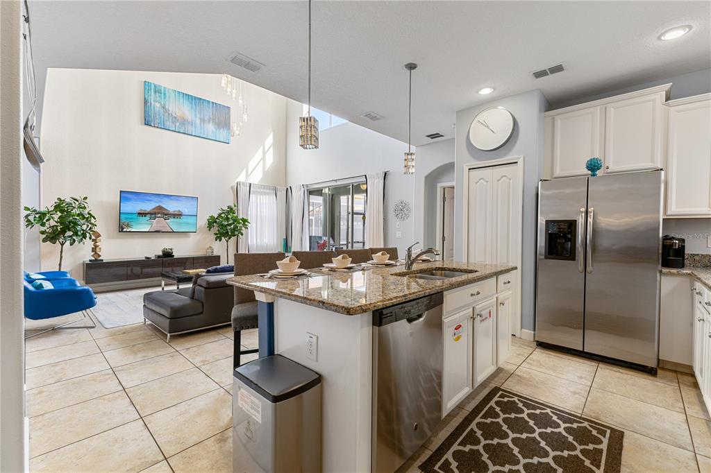 9006 Majesty Palm Road Kissimmee, FL 34747 - Photo 20 of 56 a kitchen with stainless steel appliances kitchen island granite countertop a sink and a refrigerator